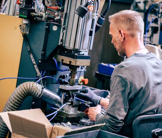 Medarbejder det sidder ved sin maskine.